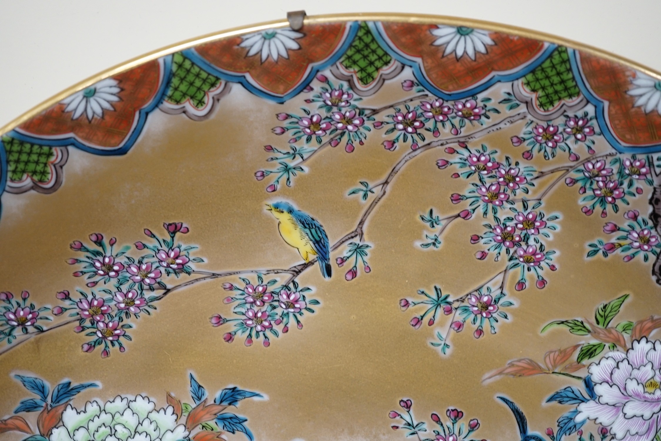 A Japanese enamelled porcelain ‘peacock’ dish on hardwood stand, dish 41cm diameter